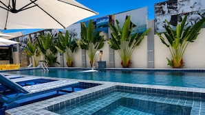 A swimming pool with tiled steps, lounge chairs, and potted plants. - Hotel Summer Beach (Paripueira)