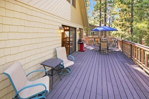 A deck with outdoor seating, a barbecue grill, and a view of trees. - 1 Mile Away From Snow Summit! PET FRIENDLY! Game Room W/ Pool + Ping Pong Combo Table & Foosball! Fenced Back Yard! Deck W/ Patio Furniture & Propane BBQ! (Big Bear Lake)