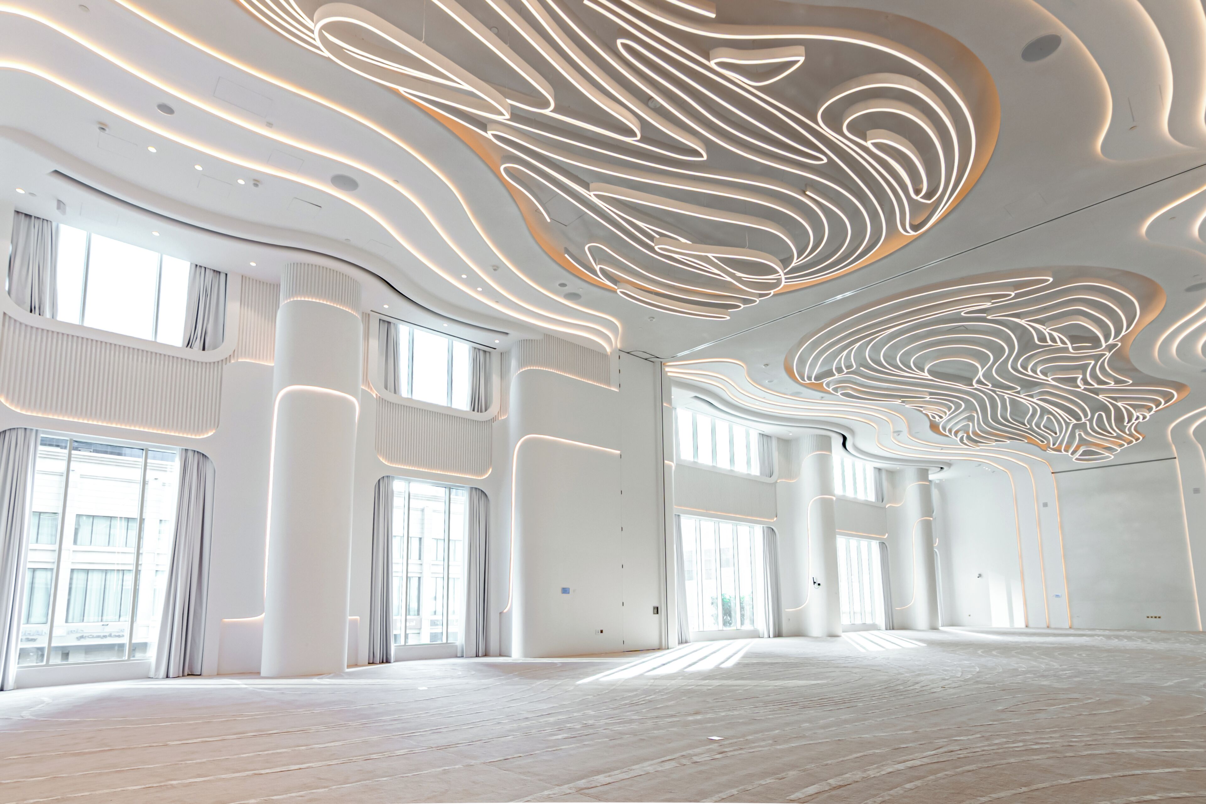 A spacious interior with high ceilings, large windows, and modern lighting design.