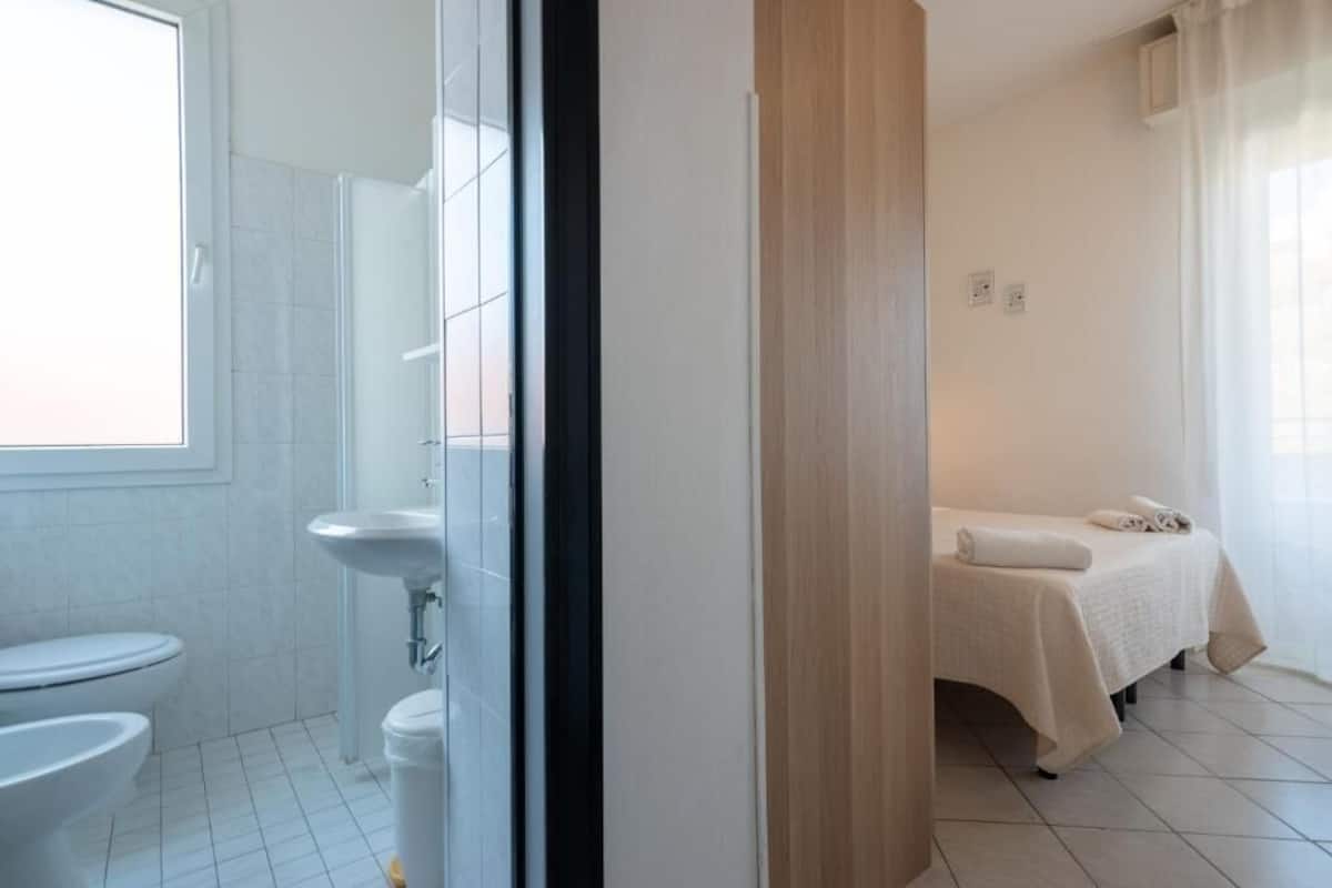 Un baño con inodoro, lavabo y ducha.