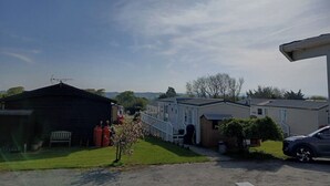 A residential area with houses, a car, and a clear sky. - Beautiful 2 bed Caravan With Views of Dartmoor (Launceston)