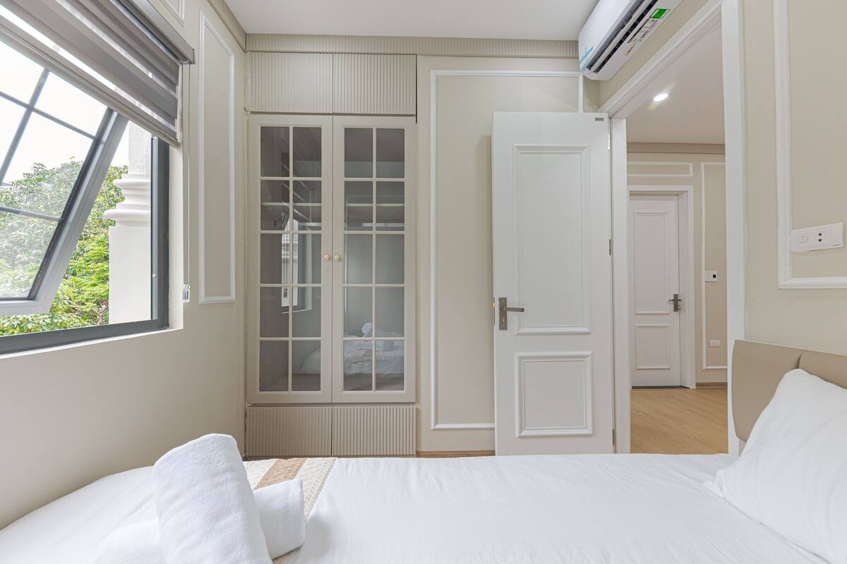 Un dormitorio con cama, armario y puerta que da a otra habitación.