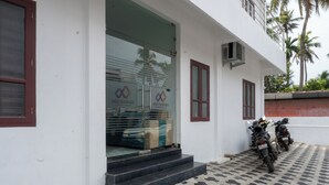 A building with a glass entrance, steps leading up to it, and a tiled floor.