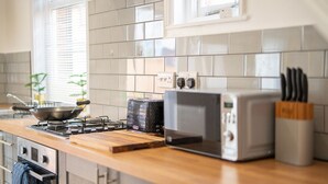 Eine Küche mit einem Gasherd, einem Toaster und einer Mikrowelle.