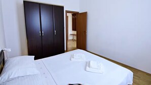 Ein Hotelzimmer mit einem Bett, einem Kleiderschrank und einem durch eine offene Tür einsehbaren Badezimmer.