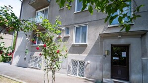 A two-story building with balconies, a door with a sign, and a small tree with red flowers. - Barrique Livezii 3 (Brașov)