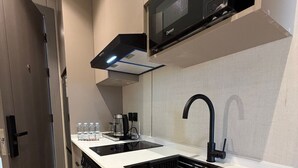Uma cozinha moderna com micro-ondas, duas pias, exaustor e lava-louças.