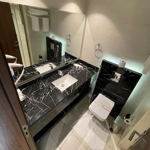 A modern bathroom with a double sink, a mirror, and a toilet. - RIO OLAYA HOTEL  (Riyadh)
