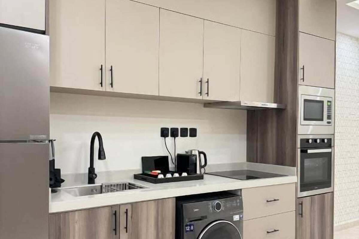 A modern kitchen with built-in appliances, wooden cabinets, and a dishwasher.