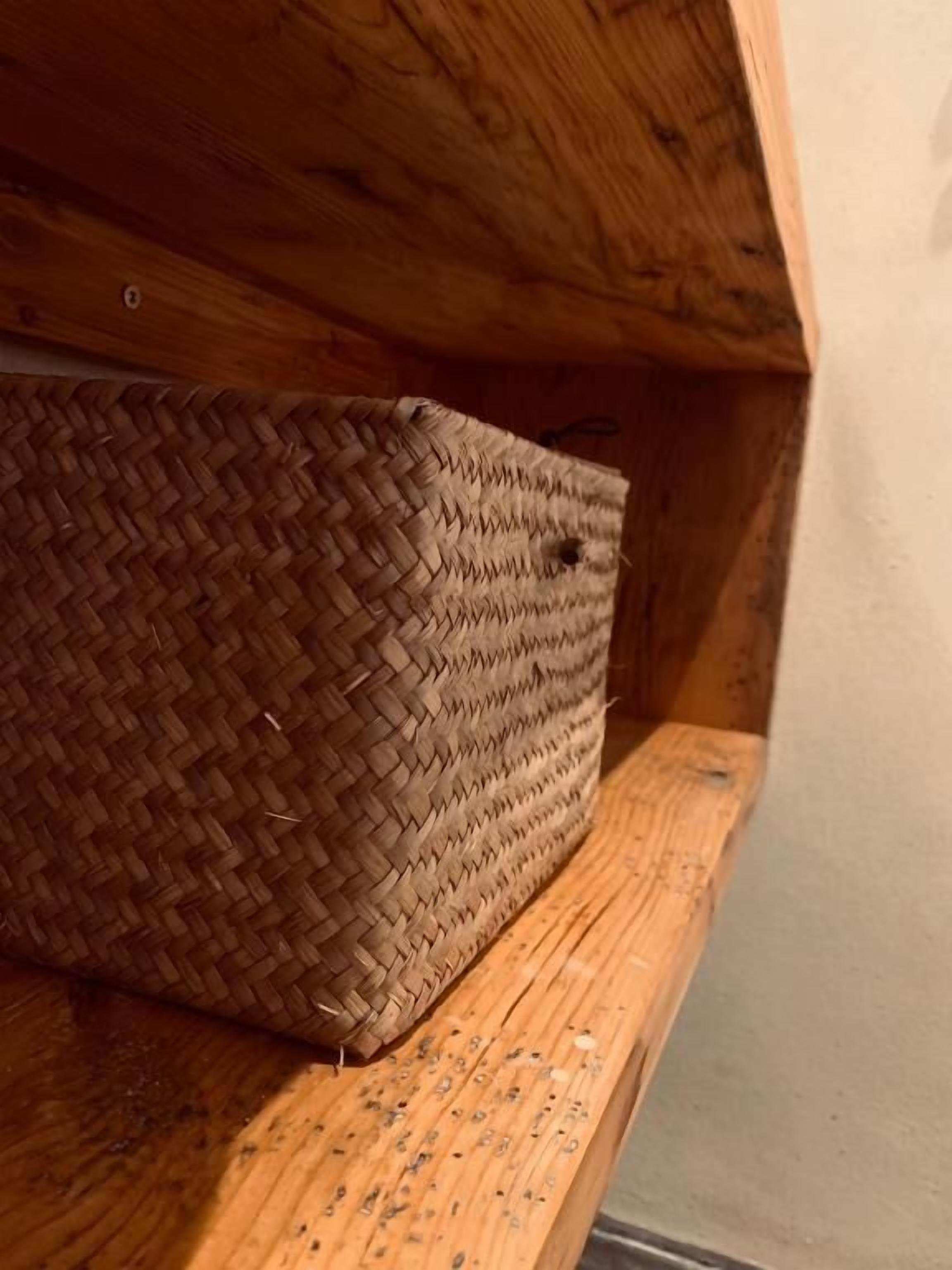Ein geflochtener Korb auf einer Holzwand.