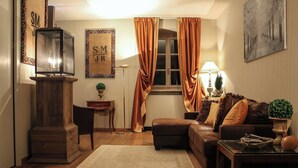 A cozy living room with a fireplace, a sofa, a coffee table, and a rug. - Elegant apartment in the center of Turin. (Torino)