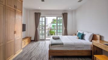 Un dormitorio con cama y armario de madera, un banco y vistas a través de un ventanal grande.