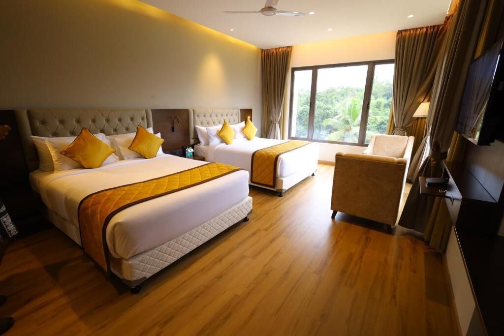A hotel room with two beds, a chair, and a large window with a view.