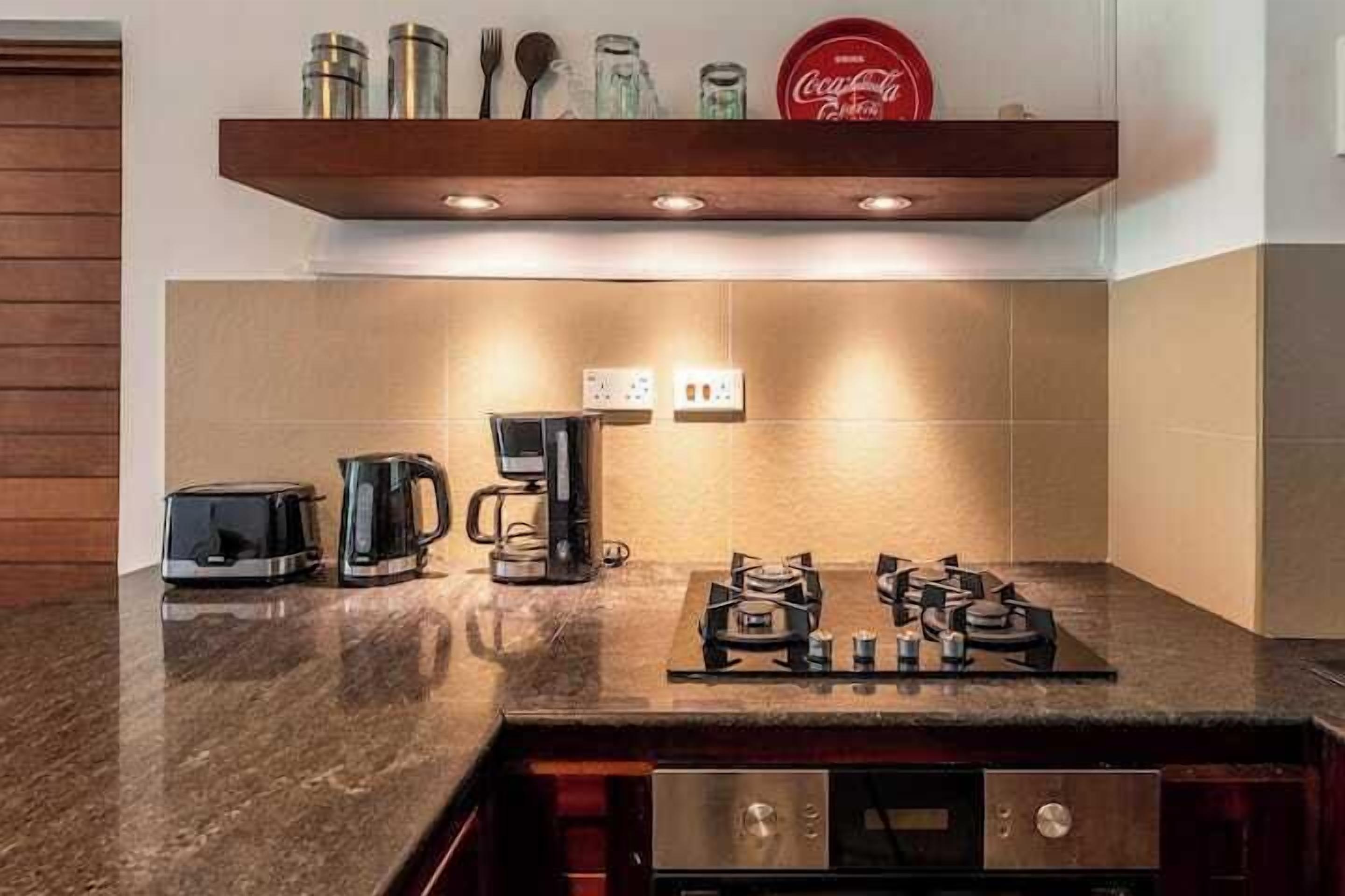 A kitchen with a gas stove, a coffee maker, and a toaster.