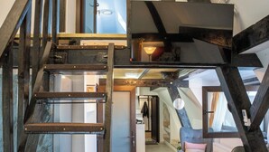 A multi-level interior with a wooden staircase, a loft bedroom, and a seating area with a view. - Barrique Milescu 5 (Brașov)