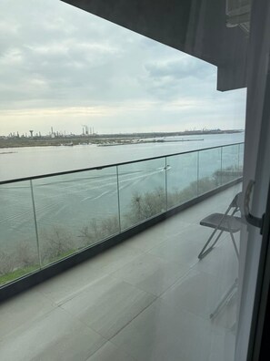 Ein Balkon mit Blick auf einen Fluss und Industriegebäude.