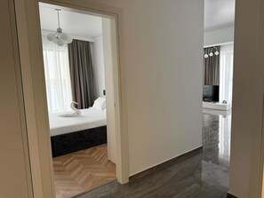 Ein Hotelzimmer mit einem Bett, einem Fernseher und Blick auf den Wohnbereich.