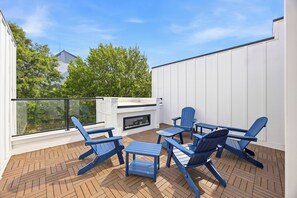 A rooftop patio with a fireplace, outdoor seating, and a view of trees and buildings. - FIFA World Cup! Walk to MBS/GWCC + View (Atlanta)