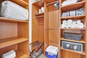 A wooden closet with shelves, a hanging rack, and a storage bin. - Stylish Studio Hotel at AKA with Free Parking (Miami)