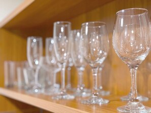 A row of empty wine glasses on a wooden shelf. - Stylish Studio Hotel at AKA with Free Parking (Miami)
