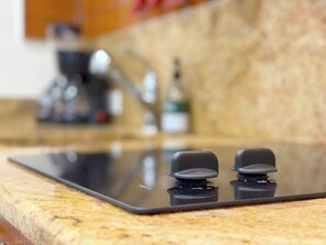 A kitchen with a countertop, a stove, and a coffee maker. - Stylish Studio Hotel at AKA with Free Parking (Miami)