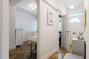A hallway with a bed, a desk, and a door leading to another room. - Stunning 3BDR Retreat Near Tower Bridge (Greater London)