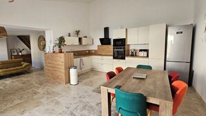 Eine moderne Küche mit Essbereich, einer Couch und einem Fernseher.