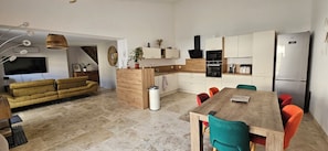 A modern kitchen with a dining area, a sofa, and a TV. - Air-conditioned house with private garden & secure parking - Maillane / Alpilles (Maillane)