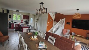 Una cocina moderna con comedor, un sofá y una televisión en la sala.