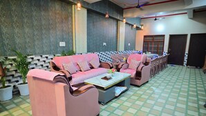 A reception area with patterned walls, a checkered floor, and two sofas with cushions. - HOTEL SIYARAM ASHRAY (Faizabad)