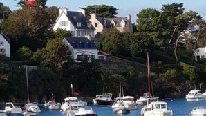 Un puerto con barcos, casas y un faro.