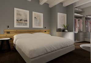 A modern bedroom with a large bed, a wooden headboard, a bedside table, and a nightstand. There are two framed abstract paintings on the wall, a mirror, and a closet with hanging clothes.
