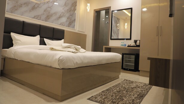 Une chambre à coucher moderne avec un grand lit, une table de chevet, un miroir et une armoire.
