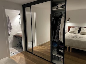 A room with a bed, a wardrobe, and a bathroom. - Renovated 17th-century wine storehouse, 4 km from Bordeaux-Lacanau cycle path. (Le Taillan-Médoc)