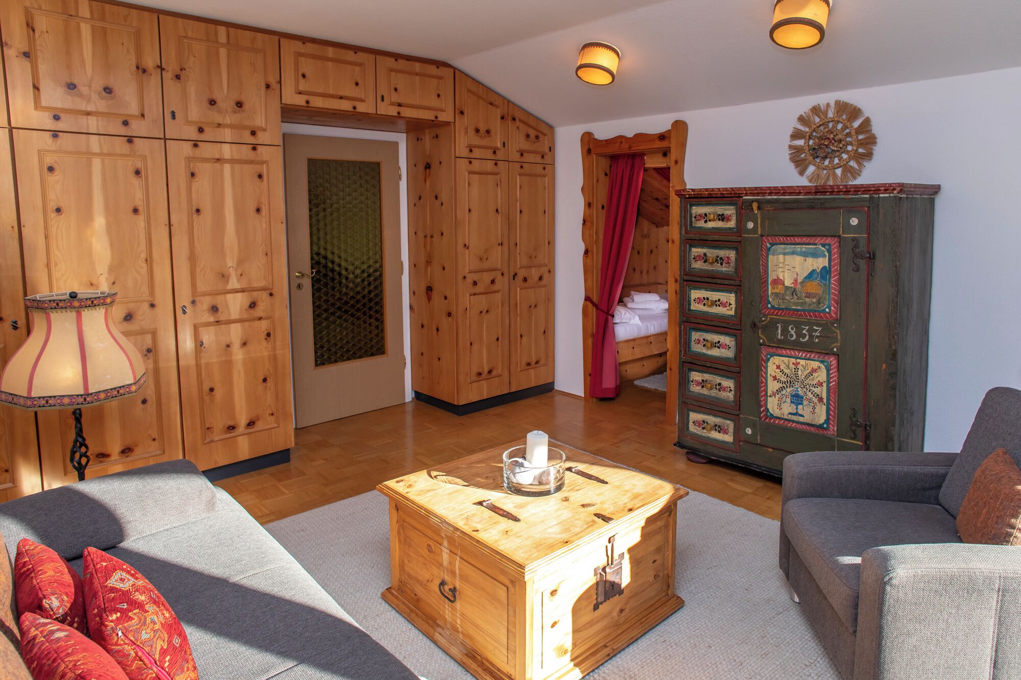 Un salon chaleureux avec des meubles en bois, un canapé, une table basse et un meuble contenant des objets décoratifs.