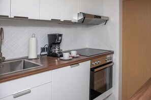 A kitchen with a coffee maker, a sink, and a stove. - Hut magic - Alpine sleep feeling - by Loewenherz (Mittenwald)