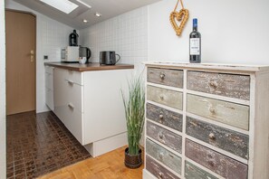 A kitchen with a coffee maker, kettle, and wine bottle on the counter. - Hut magic - Alpine sleep feeling - by Loewenherz (Mittenwald)