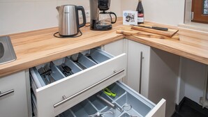 A kitchen with a coffee maker, kettle, and wine bottle on the counter. - Enchanted forest by Loewenherz (Mittenwald)
