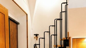 A modern kitchen with a wooden staircase featuring black metal railings. - Loft Of Mirrors In The Center Of Rome (Roma)