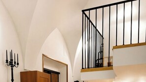 A compact living space with a staircase, a dining area, and a kitchenette. - Loft Of Mirrors In The Center Of Rome (Roma)