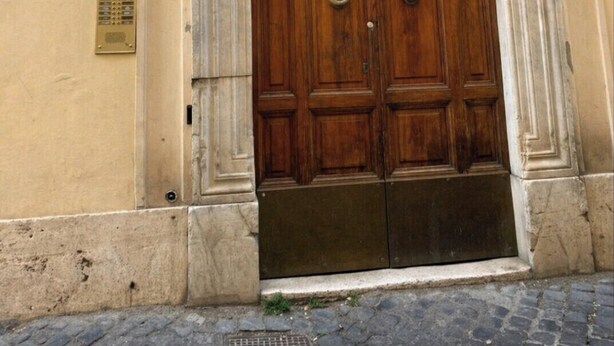 A large wooden double door with a plaque above it, a small window to the left, and a number '3' on the wall. - Loft Of Mirrors In The Center Of Rome (Roma)