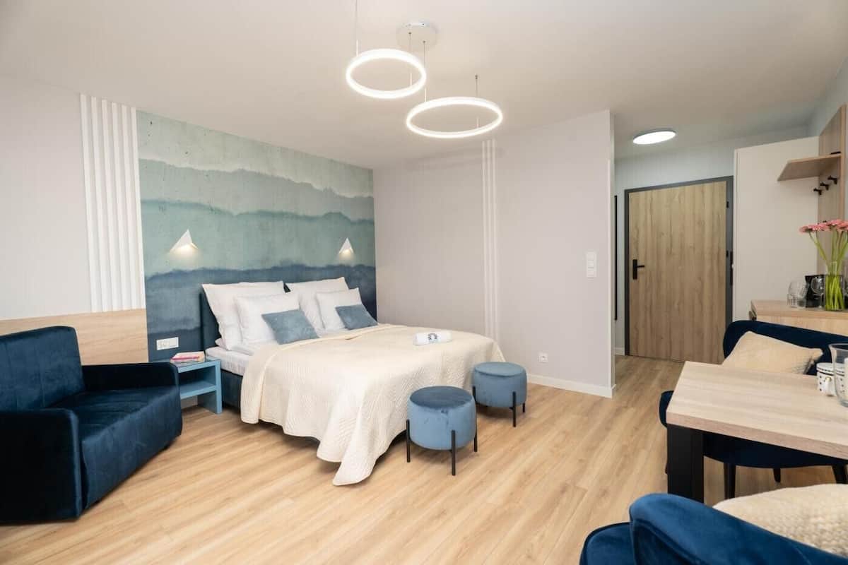Un dormitorio moderno con cama, mesitas de noche, un escritorio y una silla.