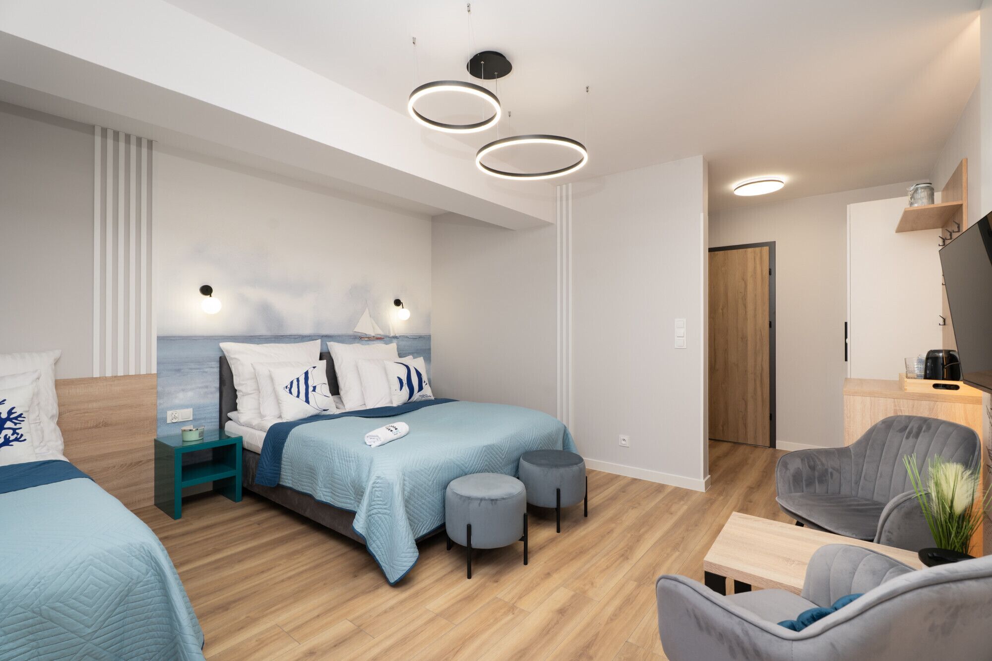 Une chambre à coucher moderne avec un lit, des tables de chevet, un bureau et une chaise.
