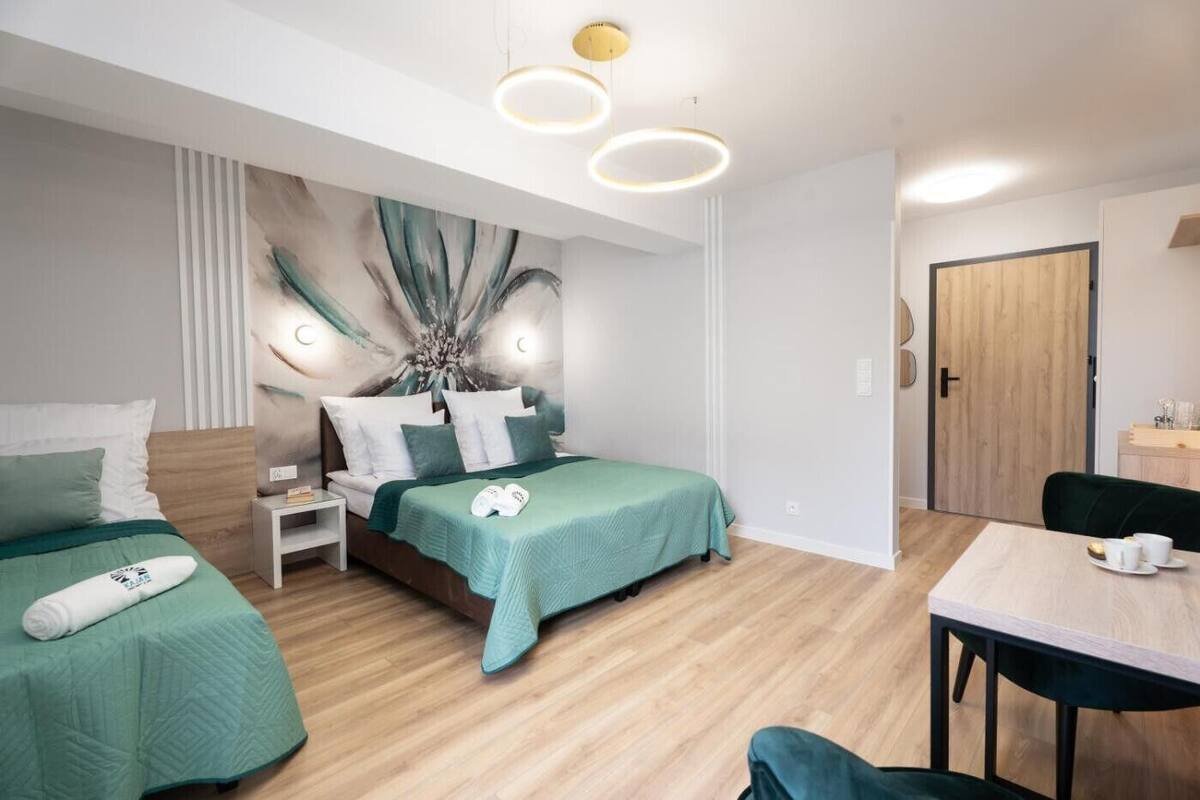 Una habitación de hotel moderna con cama, mesitas de noche, escritorio y una silla.