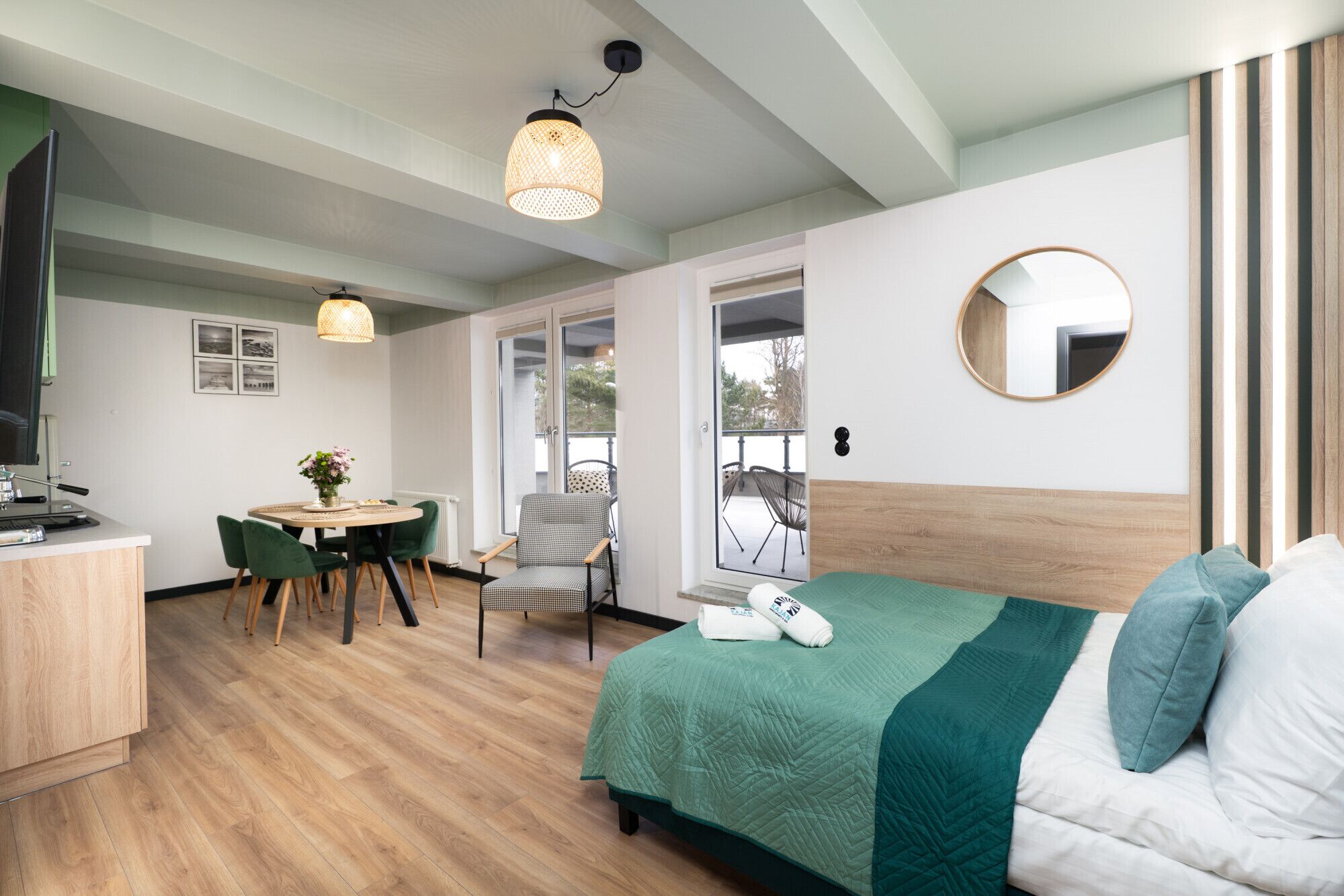 Een hotelkamer met een bed, bureau, stoel, tafel en een balkon.