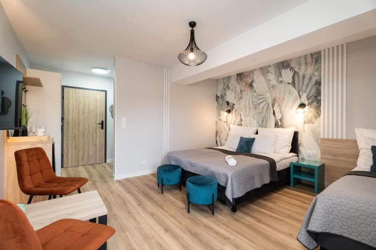 Una habitación de hotel moderna con una cama, un escritorio, una silla y una mesita.