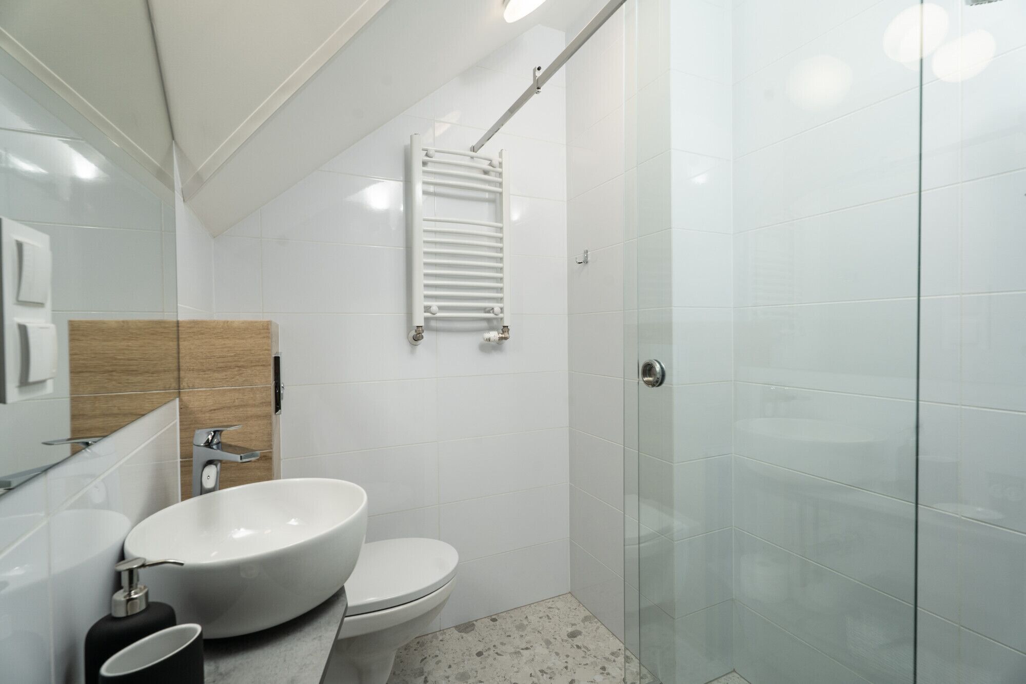 Un baño moderno con lavamanos, inodoro y cabina de ducha de vidrio.