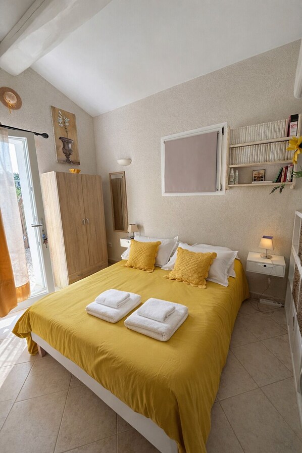 Een keurig opgemaakte slaapkamer met een bed, nachtkastjes, een garderobe en een raam.