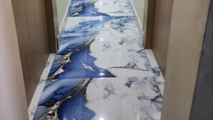 A hallway with marble flooring, wooden doors, and a view into a room with a blue curtain. - Hotel Navin Palace (Bhagalpur)