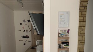 Eine kompakte Küche mit Toaster, Kaffeemaschine und einer an der Wand befestigten Ablage mit Aufbewahrungsboxen.